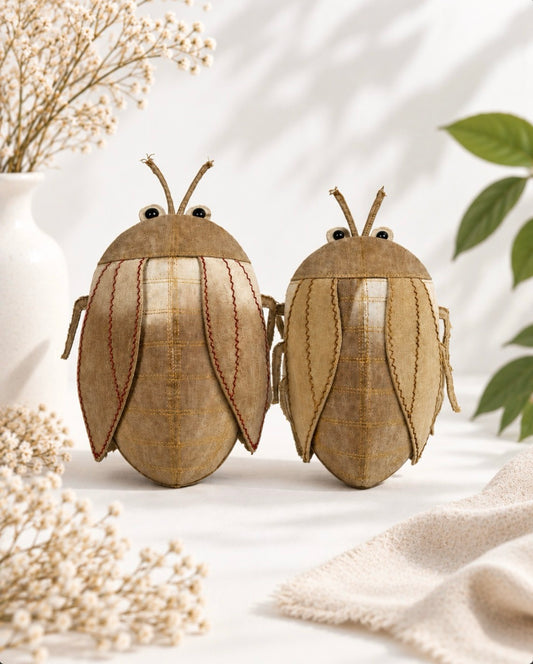 Two bags in cicada-shaped, yellow brown colour, with embroidered details in their wings 

