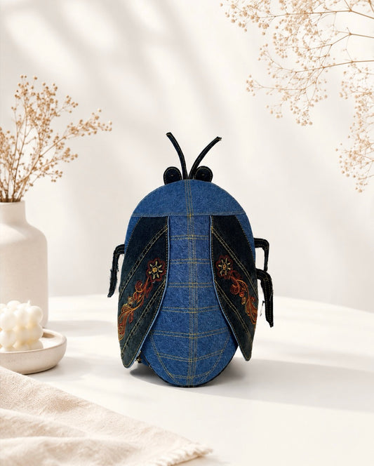 Unique denim cicada backpack with black wings and embroidered details